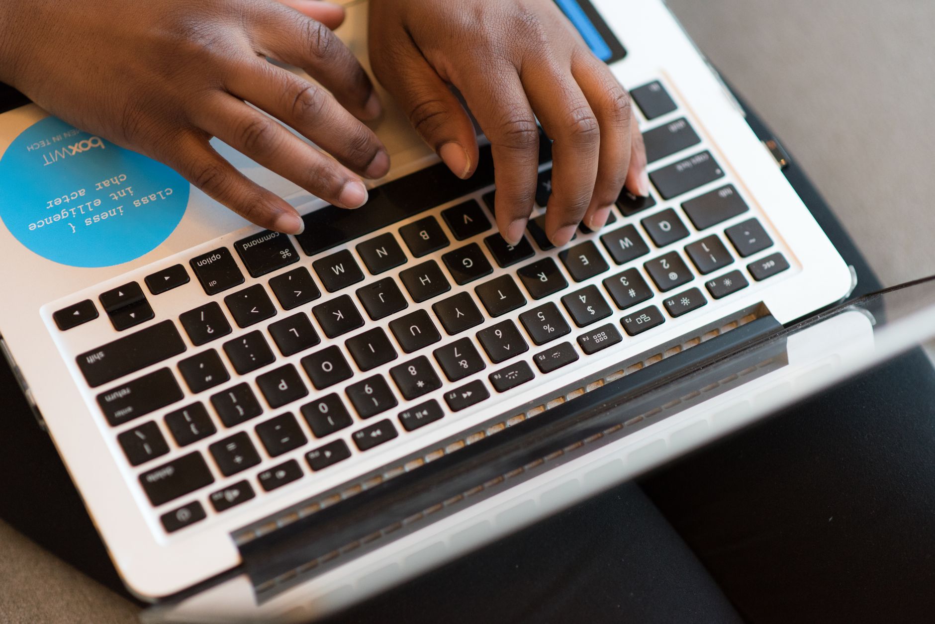 Mains d’une personne tapant sur le clavier d’un ordinateur portable.